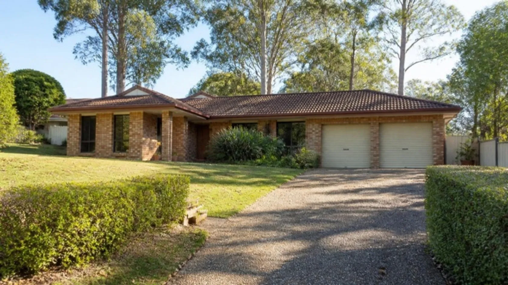 Neatly mown lawn at a brick-and-tile family home with gum trees
