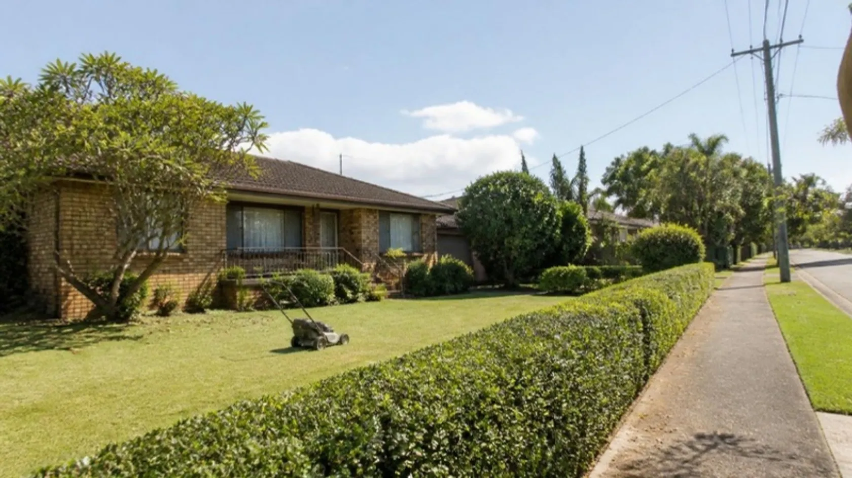 Freshly mown front lawn at a low-set brick home